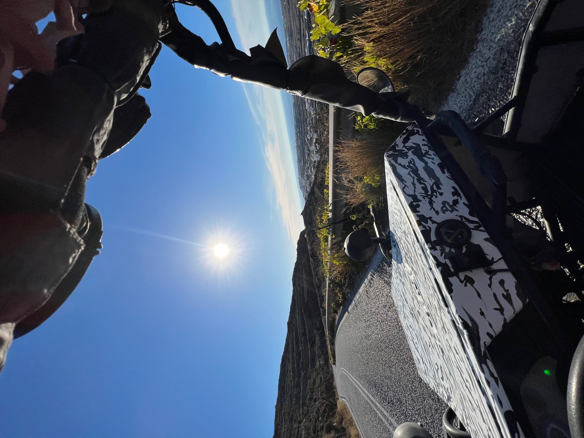 POV from inside a rental buggy cruising Santorini